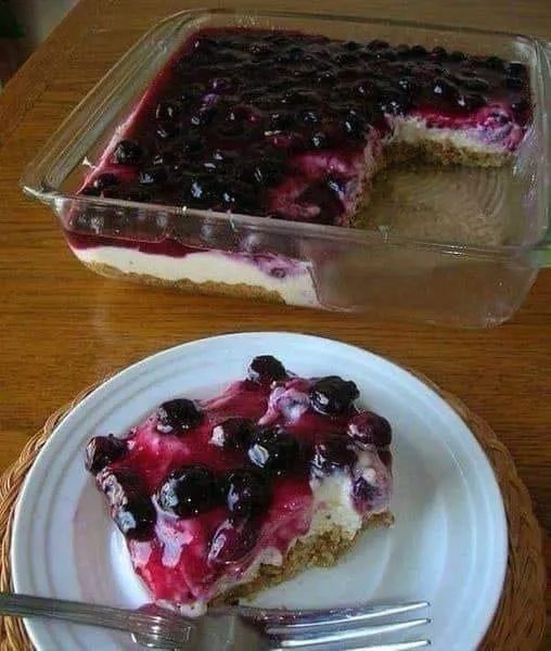 A slice of pie with blueberries on a plate.