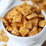 A bowl of golden, textured cereal pieces coated in a sticky, sweet glaze and sprinkled with salt.