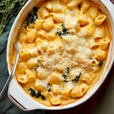 A creamy mac and cheese dish with kale, topped with breadcrumbs and melted cheese, served in a white casserole dish.