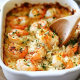 A creamy baked dish featuring golden shrimp topped with herbs and breadcrumbs, served in a white casserole dish.