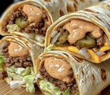 A burrito with sauce on it.
